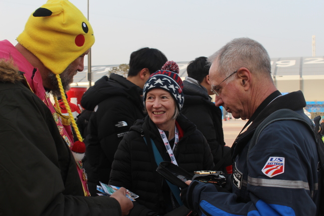 Olympic pin trader Daniel Presburger (center) displays his pins Saturday at the Gangneung Olympic Park, Gangwon Province. Bak Se-hwan/The Korea Herald