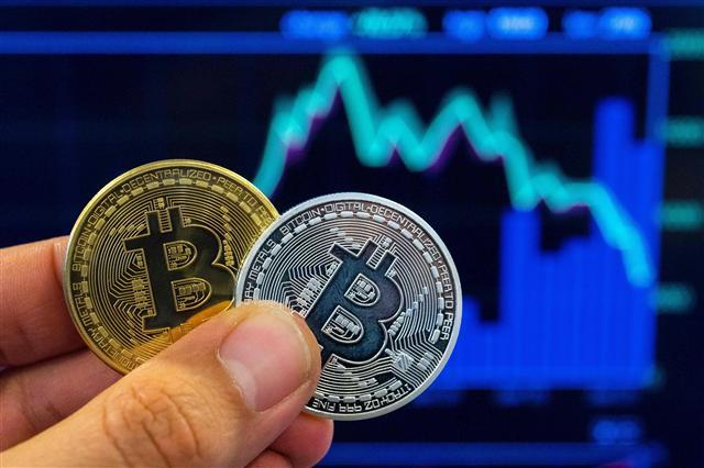 <YONHAP PHOTO-6128> A picture taken on February 6, 2018 shows a person holding a visual representation of the digital crypto-currency Bitcoin, at the "Bitcoin Change" shop in the Israeli city of Tel Aviv. / AFP PHOTO / JACK GUEZ/2018-02-06 23:18:10/ <저작권자 ⓒ 1980-2018 ㈜연합뉴스. 무단 전재 재배포 금지.>