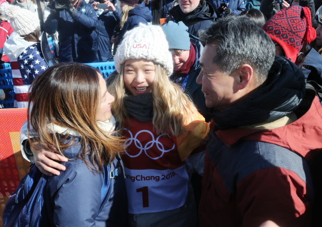 Korean-American snowboarder Chloe Kim hugs her parents after winning the gold medal in the women's halfpipe of the PyeongChang Winter Olympic Games at Phoenix Snow Park in PyeongChang, Gangwon Province, on Tuesday. (Yonhap)
