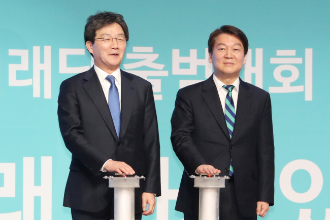 Yoo Seong-min (L), co-leader of the Bareun Future Party and Ahn Cheol-soo, former leader of the People's Party press a button signaling the launch of the new party.