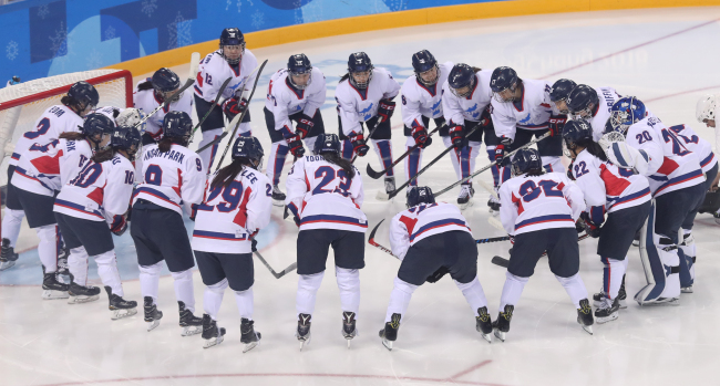 The joint Korean women's hockey team players huddle around the net before the start of their classification game against Switzerland at Kwandong Hockey Centre in Gangneung, Gangwon Province, during the 2018 Winter Olympics on Sunday. (Yonhap)