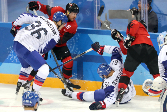 South Korea's Park Woo-sang (L) and Lee Don-ku (2nd from R) go up against Canada during the teams' Group A match at Gangneung Hockey Centre in Gangneung, Gangwon Province, during the Winter Olympics on Sunday. (Yonhap)