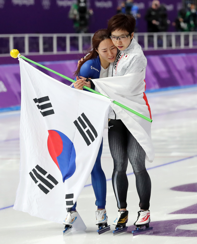 South Korea's Lee Sang-hwa (left) is being comforted by Japan's Nao Kodaira during their lap of honor at PyeongChang Winter Games on Sunday. Lee claimed her silver, while Kodaira won the gold in Women's 500-meter speedskating final. (Yonhap)
