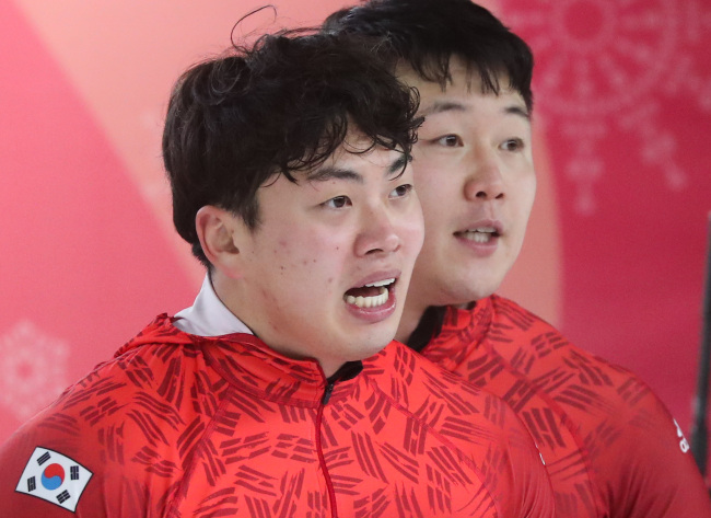 Korean tandem Won Yun-jong (back) and Seo Young-woo checks their time record after finishing the two-man bobsleigh competition at the PyeongChang Winter Olympic Games in PyeongChang on Feb. 19, 2018. (Yonhap)