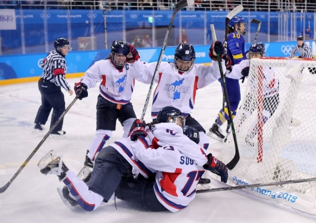Korean players celebrate after Han Soo-jin (R on the ice) scored a goal against Sweden during the seventh place match in the women's hockey tournament of the PyeongChang Winter Olympics at Kwandong Hockey Centre in Gangneung, Gangwon Province, on Feb. 20, 2018. (Yonhap)