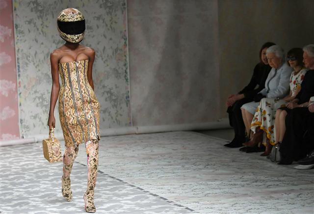 <YONHAP PHOTO-1060> epa06547175 Britain's Queen Elizabeth II (2-L) sits with Chief Executive of the British Fashion Council Caroline Rush (L) and Editor-in-chief of Vogue magazine Anna Wintour (3-L) as models present creations by British designer Richard Quinn during the London Fashion Week, in London, Britain, 20 February 2018. The presentation of the Women's Fall-Winter 2018/2019 collections runs from 15 to 20 February. EPA/NEIL HALL/2018-02-21 04:53:53/ <저작권자 ⓒ 1980-2018 ㈜연합뉴스. 무단 전재 재배포 금지.>