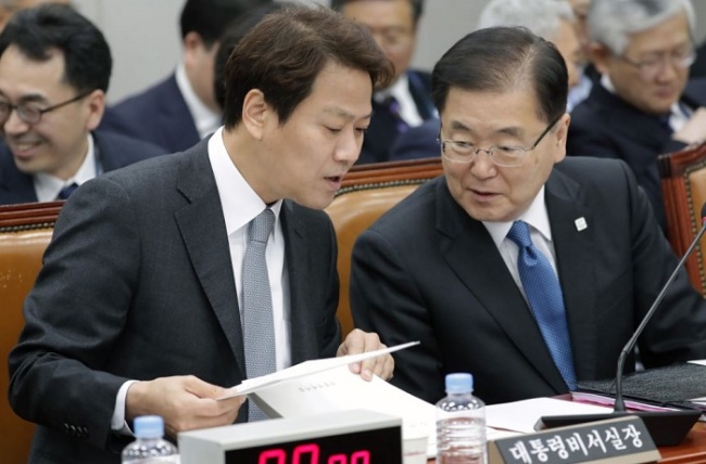 Chung Eui-yong (R), chief of the presidential National Security Office, talks with presidential chief of staff Im Jong-seok during a parliamentary steering committee meeting on Feb. 21, 2018. (Yonhap)