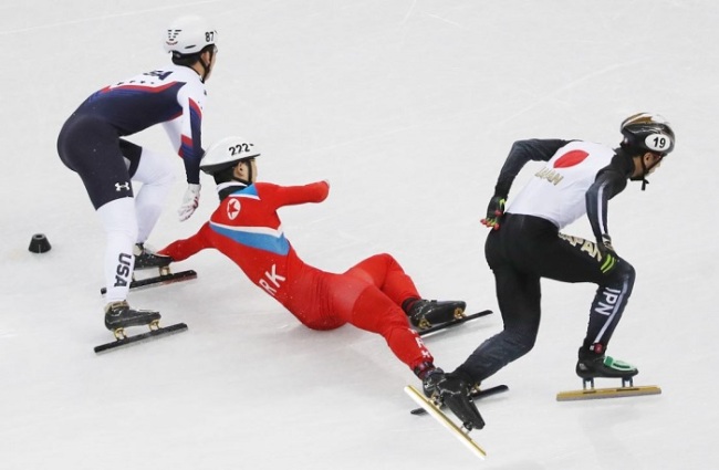 North Korean short track speed skater Jong Kwang-bom (C) falls down during a preliminary race in the men's 500 meters at Gangneung Ice Arena in Gangneung during the PyeongChang Winter Olympics on Feb. 20, 2018. (Yonhap)