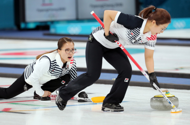 Kim Eun-jung (left), the skip of South Korea’s women’s curling team competes against OAR during a round-robin match held Wednesday. The game ended with Korea defeating OAR 11-2. (Yonhap)