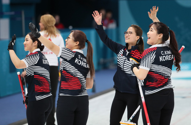 Members of the South Korean women's curling team wave to the audience after defeating Denmark in a round-robin match held on Wednesday. (Yonhap)
