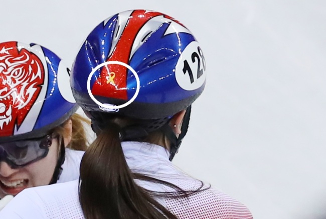 South Korean short track speedskater Kim A-lang competes at PyeongChang games wearing a helmet featuring a sticker (circled in white)that looks like a yellow ribbon, which commemorates the victims of Sewol ferry disaster. (Yonhap)