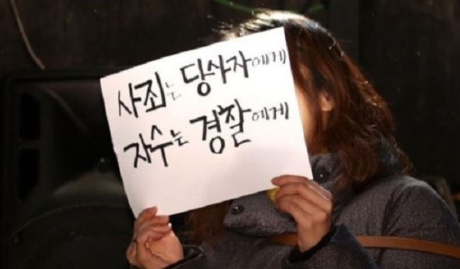 A woman holds a banner reading, “Apologize to the party concerned, surrender to the police” at a press conference to protest against theatrical director Lee Youn-taek in Seoul on Feb. 19. (Yonhap)