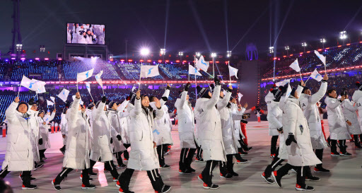North Korean hockey player Hwang Chung-gum (left) and South Korean bobsled pilot Won Yun-jong carry the Korean Unification Flag during the opening ceremony of the Winter Games at the Olympic Stadium in PyeongChang, Gangwon Province, on Feb.9. (Yonhap)