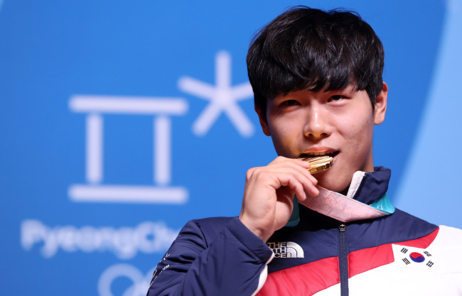 In this file photo taken Feb. 21, 2018, South Korean skeleton slider Yun Sung-bin bites his gold medal during a press conference at the Main Press Center in PyeongChang, Gangwon Province. (Yonhap)