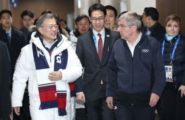South Korean President Moon Jae-in, left, and IOC President Thomas Bach walk together to enter the Olympics' closing ceremony on Sunday. (Yonhap)