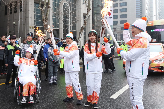 Torchbearers for the PyeongChang Winter Paralympic Games pose for a photo during the torch relay in Seoul on Sunday. (Yonhap)