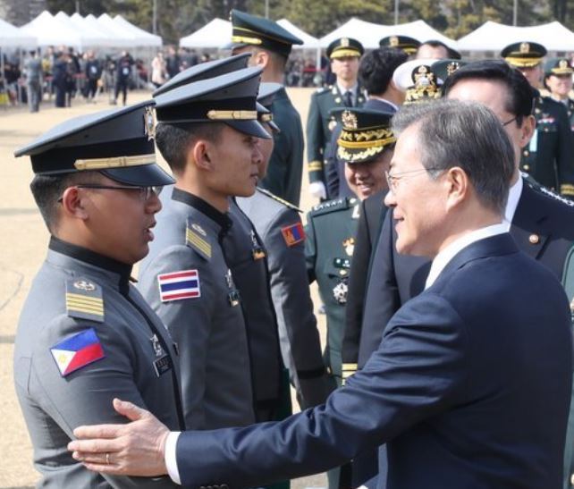 President Moon Jae-in (R) shakes hands with a graduate of the Korea Military Academy at a graduation ceremony held at the academy in Seoul on March 6. (Yonhap)