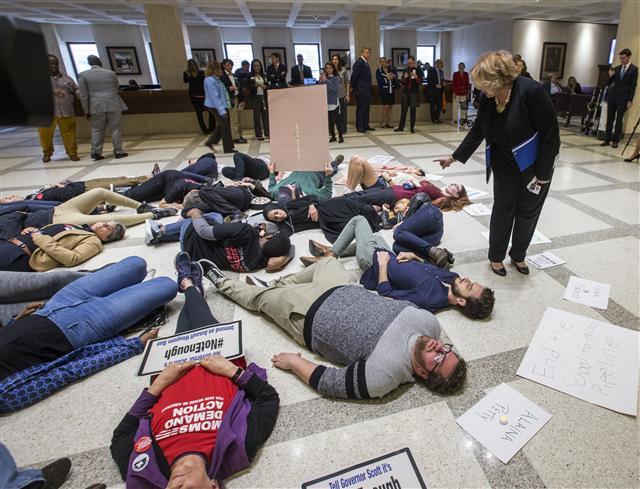 <YONHAP PHOTO-0688> Florida Rep. Janet Cruz (D-Tampa) walks around a group of 20 college students and activists as they stage a die-in on the 4th floor rotunda between the House and Senate chambers while the House takes up the school safety bill at the Florida Capital in Tallahassee, Fla., Tuesday March 6, 2018. (AP Photo/Mark Wallheiser)/2018-03-07 05:22:50/ <저작권자 ⓒ 1980-2018 ㈜연합뉴스. 무단 전재 재배포 금지.>