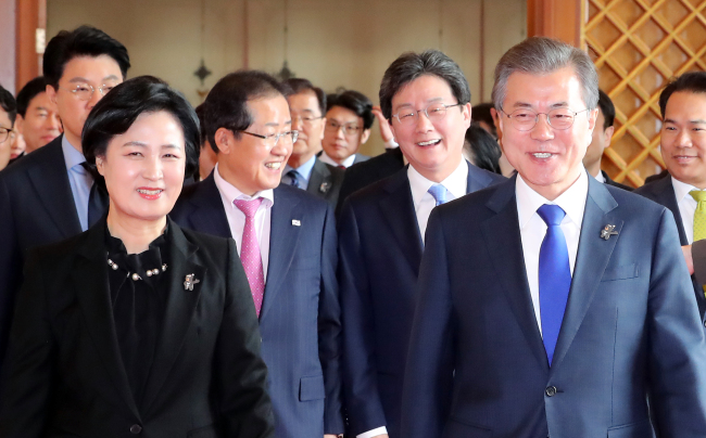 President Moon Jae-in (right) heads to a luncheon meeting with parties' leaders at the presidential office on Wednesday. Yonhap