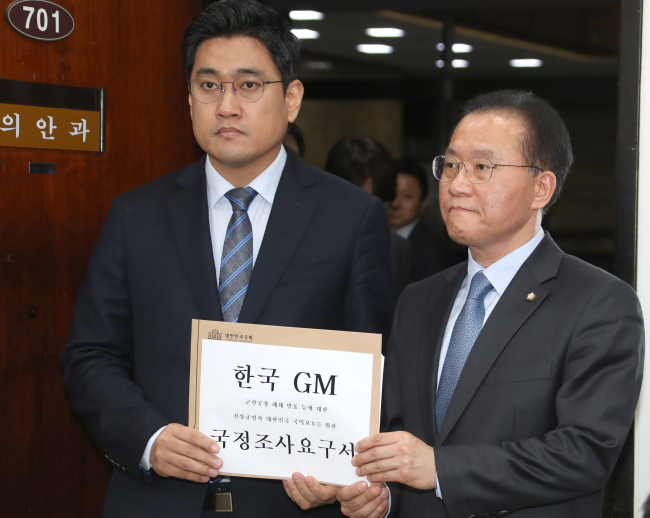 Rep. Yun Jae-ok (R) of the main opposition Liberty Korea Party and Rep. Oh Shin-hwan of the minor Bareunmirae Party submit a request for a parliamentary probe into GM Korea's decision to shut down a plant in the southwestern city of Gunsan at the National Assembly in Seoul on March 8, 2018. (Yonhap)
