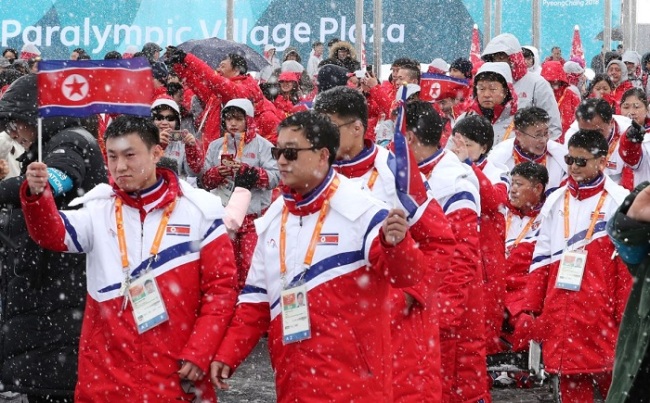 North Korean athletes and officials for the PyeongChang Winter Paralympics wave their national flag during the welcome ceremony at the athletes' village in PyeongChang, Gangwon Province, on March 8. (Yonhap)
