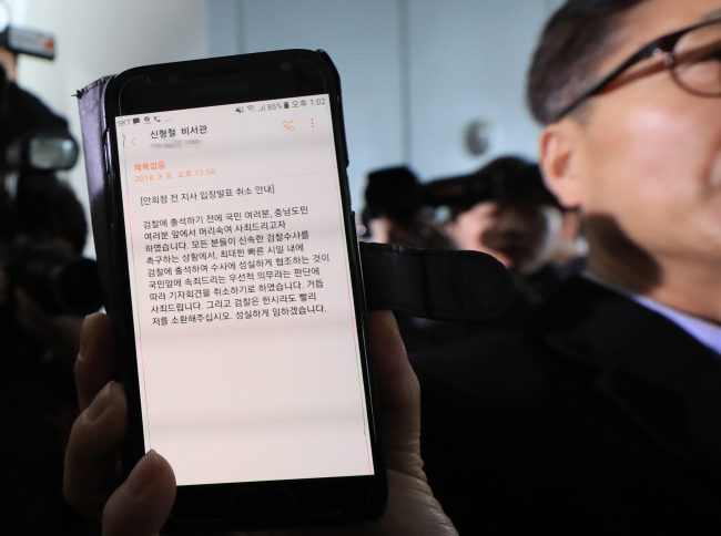An official shows the text message delivering former governor An Hee-jung's statement to cancel the press conference previously slated for 3 p.m. Thursday. (Yonhap)
