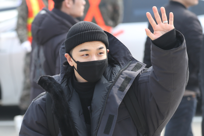 Taeyang waves at fans at his enlistment site in Cheorwon, Gangwon Province. (Yonhap)