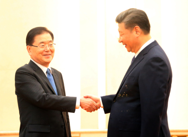 Chinese President Xi Jinping greets Seoul's National Security Office chief Chung Eui-yong in Beijing on Monday. Yonhap