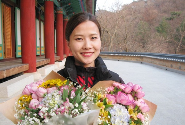 South Korean curler Kim Eun-jung poses for a photo with flowers at Goun Temple in Euiseong, North Gyeongsang Province, on March 12. (Yonhap)