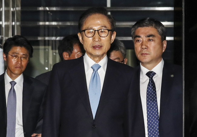 Former President Lee Myung-bak emerges from the Seoul Central District Prosecutors' Office on Thursday. Yonhap