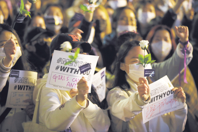 3·8 여성의날 110주년인 8일 오후 서울 마포구 홍대입구역 인근에서 열린 ‘제1회 페미 퍼레이드’ 참가자들이 ‘미투(METOO)&위드유(WITHYOU)’운동을 지지하는 흰색 장미를 들고서 참가자들의 발언을 듣고 있다.  [연합뉴스]