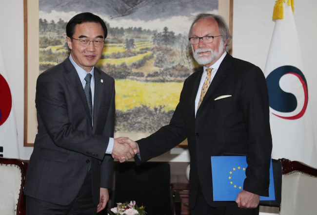 This photo, taken on March 16, 2018, shows Unification Minister Cho Myoung-gyon (L) and Michael Reiterer, the European Union's top envoy to South Korea, shaking hands ahead of their meeting. (Yonhap)