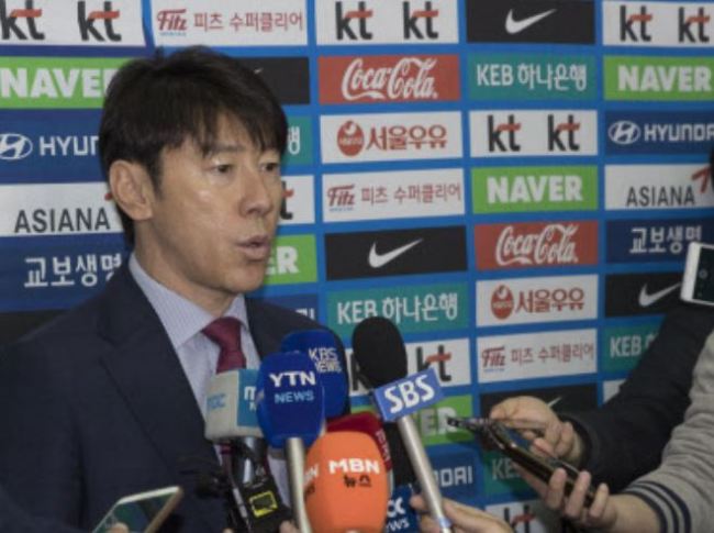 South Korea men's national football team head coach Shin Tae-yong (L) speaks to reporters at Incheon International Airport, west of Seoul, on March 19. (Yonhap)