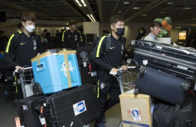 South Korean national football team players move luggage carts after arriving at Dublin Airport in Dublin on March 19. (Yonhap)