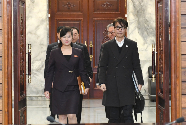 Hyun Song-wol (left), leader of North Korea all-female Moranbong Club and Yun Sang (right), South Korean singer-songwriter enter the Tongilgak administrative building on the northern side of the Demilitarized Zone on Tuesday for working-level talks. (Ministry of Unification)