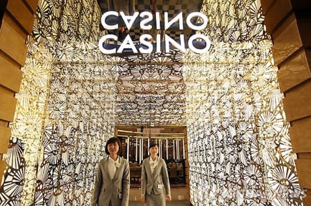 Two employees of the foreigners-only Seven Luck Casino in Seoul, run by GKL, welcome visitors. (Yonhap)