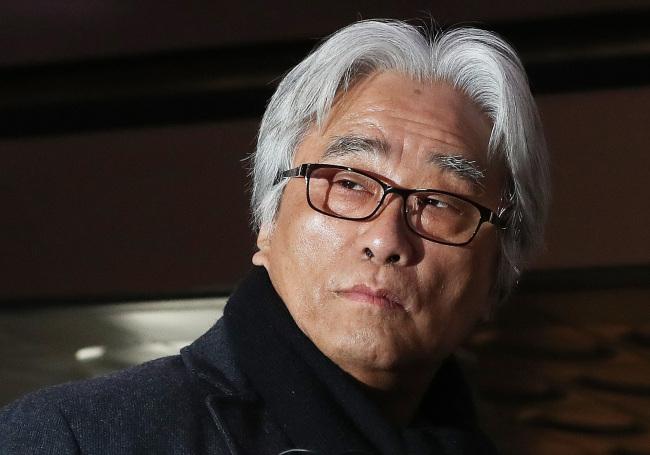 Lee Youn-taek, a disgraced South Korean theater writer and director, is seen at the Seoul Metropolitan Police Agency on Sunday, where he appeared for questioning over multiple sexual allegations. (Yonhap)