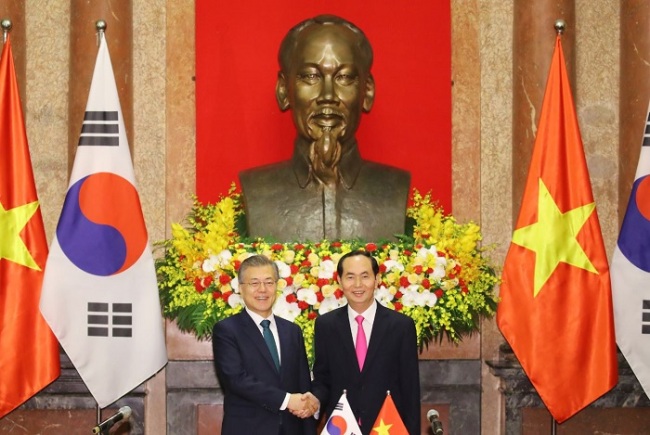 South Korean President Moon Jae-in (L) and Vietnamese President Tran Dai Quang shake hands before the start of their bilateral summit in Hanoi on March 23. (Yonhap)
