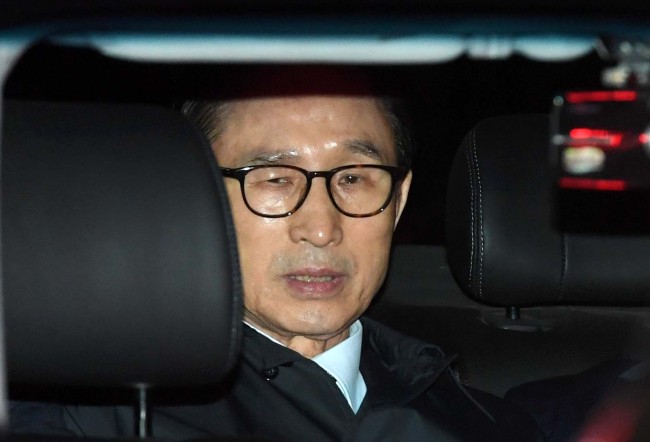 Former President Lee Myung-bak seen inside a vehicle as he was taken into custody on Friday. Yonhap