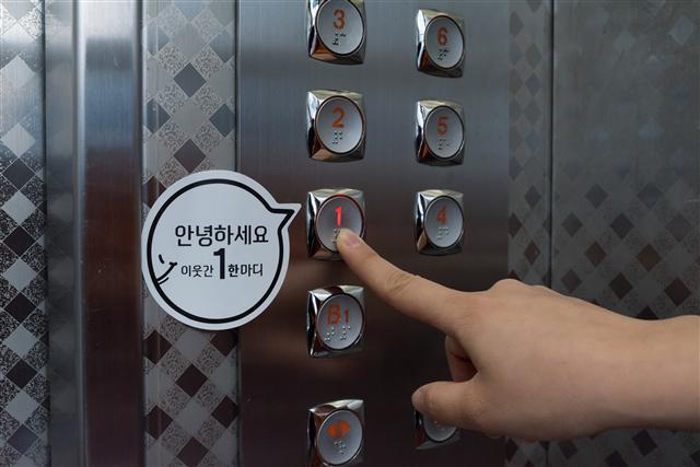 안녕하세요 스티커가 부착된 엘리베이터 모습(왼쪽 사진). 머그컵 전용좌석 캠페인을 하고 있는 cafe507 내부 모습.