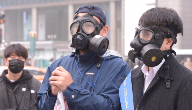 고농도 미세먼지와 짙은 안개가 전국을 덮고 있다.  올해 들어 두 번째로 수도권 미세먼지 '비상저감조치'가 시행된 26일 광화문 네거리에서  서울시와 시민단체들이 차량2부제와 대중교통 이용 캠페인을 벌이고 있다. 일부참가자들은 방독면을 쓰고 미세먼지 저감대책을 촉구했다. 서풍을 타고 온 국외 오염물질과 머물던 국내 오염물질이 한반도 상공을 빠져나가지 못함에 따라 이어지고 있는 최악의 수도권 미세먼지는 27일까지 '나쁨' 수준을 보일 것으로 예측된다. <br />정희조 기자/checho@heraldcorp.com  180326