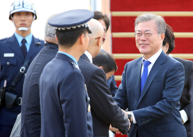 President Moon Jae-in is greeted by officials as he arrives back in Korea on Wednesday. Yonhap