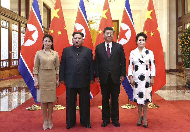 Chinese President Xi Jinping, second from right, and his wife Peng Liyuan, right, and North Korean leader Kim Jong-un, second from left, and his wife Ri Sol-ju , left, pose for a photo at the Great Hall of the People in Beijing. (AP-Yonhap)