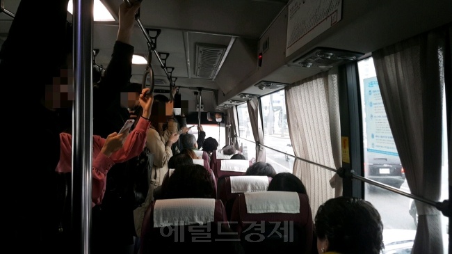 달리는 버스 안에서 한 손으로 스마트폰을 쥐고 있는 승객들.  정세희 기자/say@