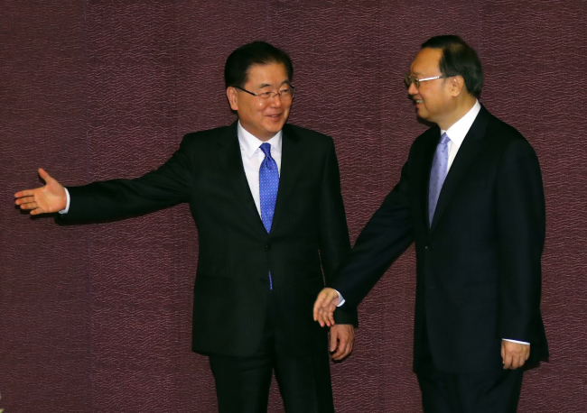 Chung Eui-yong (L), top security advisor to South Korean President Moon Jae-in, ushers Chinese State Councilor Yang Jiechi into the venue for their talks at a Seoul hotel on March 29, 2018. (Yonhap)