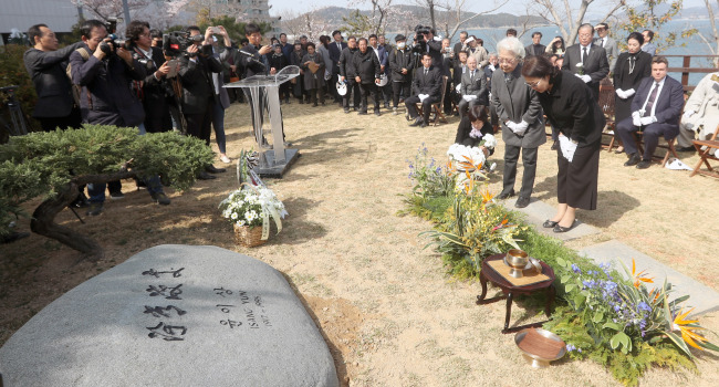 Composer Yun I-sang‘s wife Lee Su-ja (second from right) bows to the grave of her husband at a memorial ceremony held on Friday in Tongyeong, South Gyeongsang Province. (Yonhap)