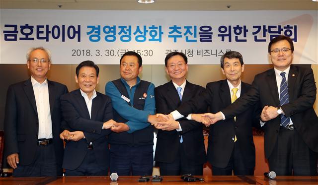 지난달 30일 오후 광주시청에서 금호타이어 노사, 채권단, 노사정이 긴급간담회를 5시간여를 진행한 끝에 ‘더블스타로 자본유치 및 경영정상화 방안’에 대해 상호 합의하고 손을 맞잡고 포즈를 취하고 있다.  [연합뉴스]