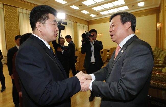 South Korean Sports Minister Do Jong-whan (right) and his North Korean counterpart, Kim Il-guk, shake hands before their meeting at the Mansudae Assembly Hall in Pyongyang on Monday. (Yonhap)