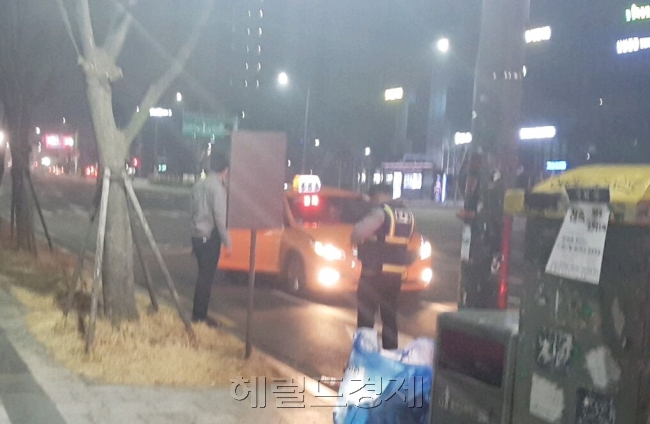 지구대 소속 경찰관들이 취객을 택시에 태워 보내고 있는 모습. [사진=김성우 기자/zzz@heraldcorp.com]