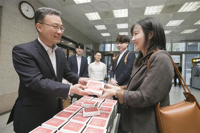 케이뱅크 심성훈 은행장이 3일 출범 1주년을 맞이해 서울시 서대문구 충정사옥 고객센터에서 출근하는 직원들에게 기념 떡을 나눠주고 있다.  [제공=케이뱅크]